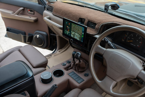Beige interior of a vehicle with dashboard, steering wheel, and navigation system.
