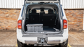 White SUV 250 Prado with open trunk in a parking lot to show before and after photo of rear seat delete storage results
